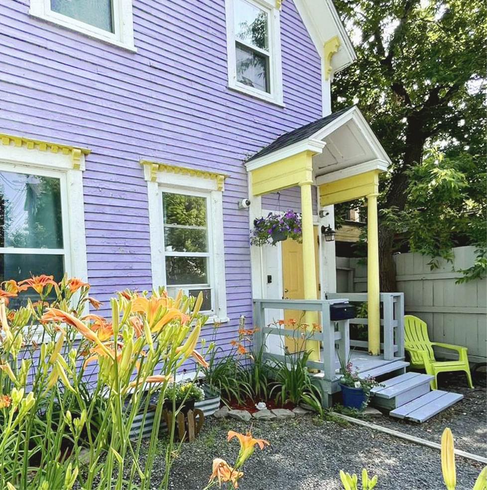 Grace House: A purple and yellow house surrounded by flowers