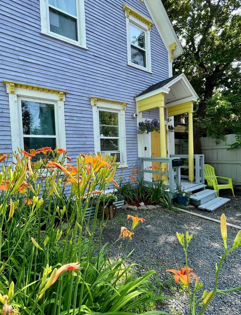 Grace House: A purple and yellow house surrounded by flowers