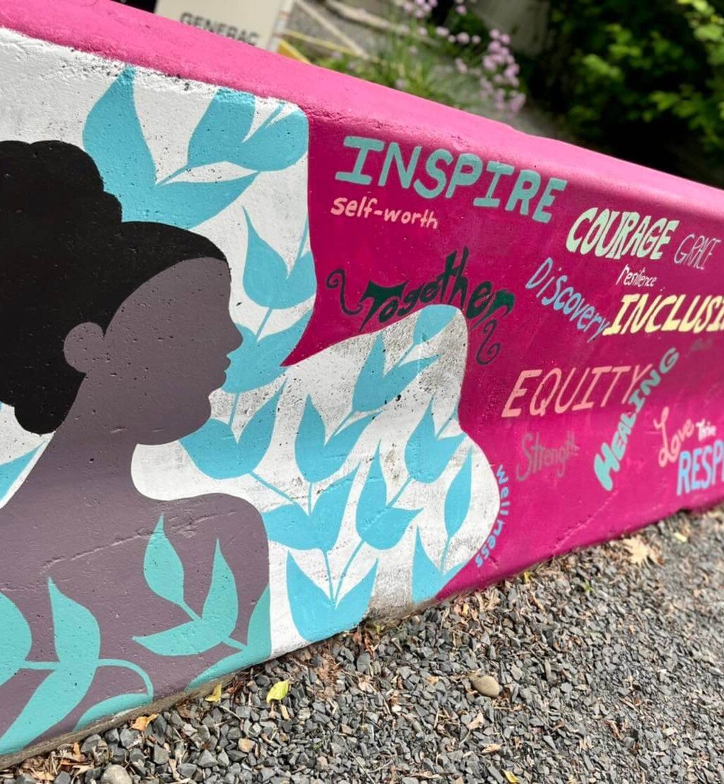 An inspirational mural showing inclusivity and courage painted on concrete